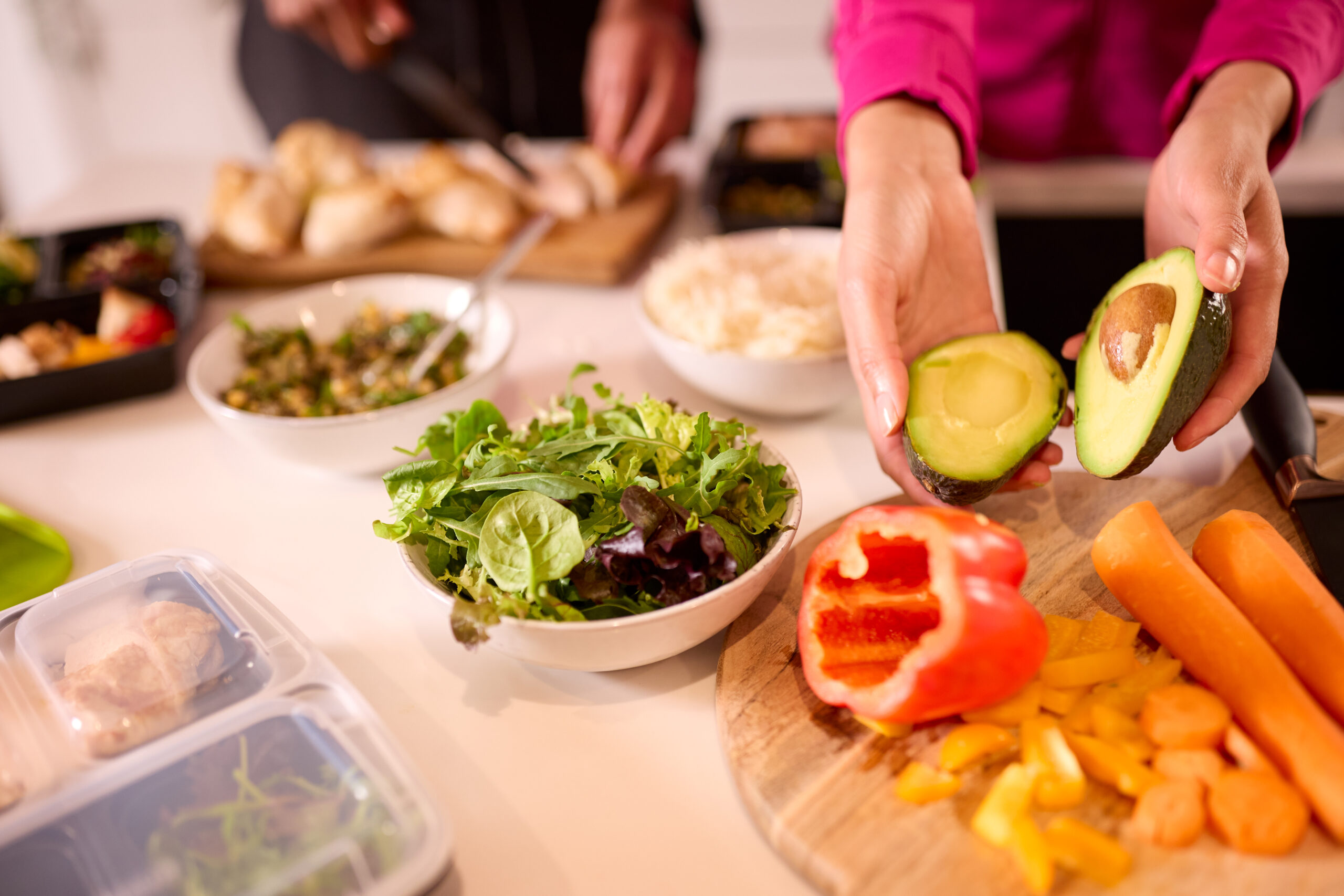 close up view of a couple in the kitchen wearing fitness clothes and preparing a healthy meal