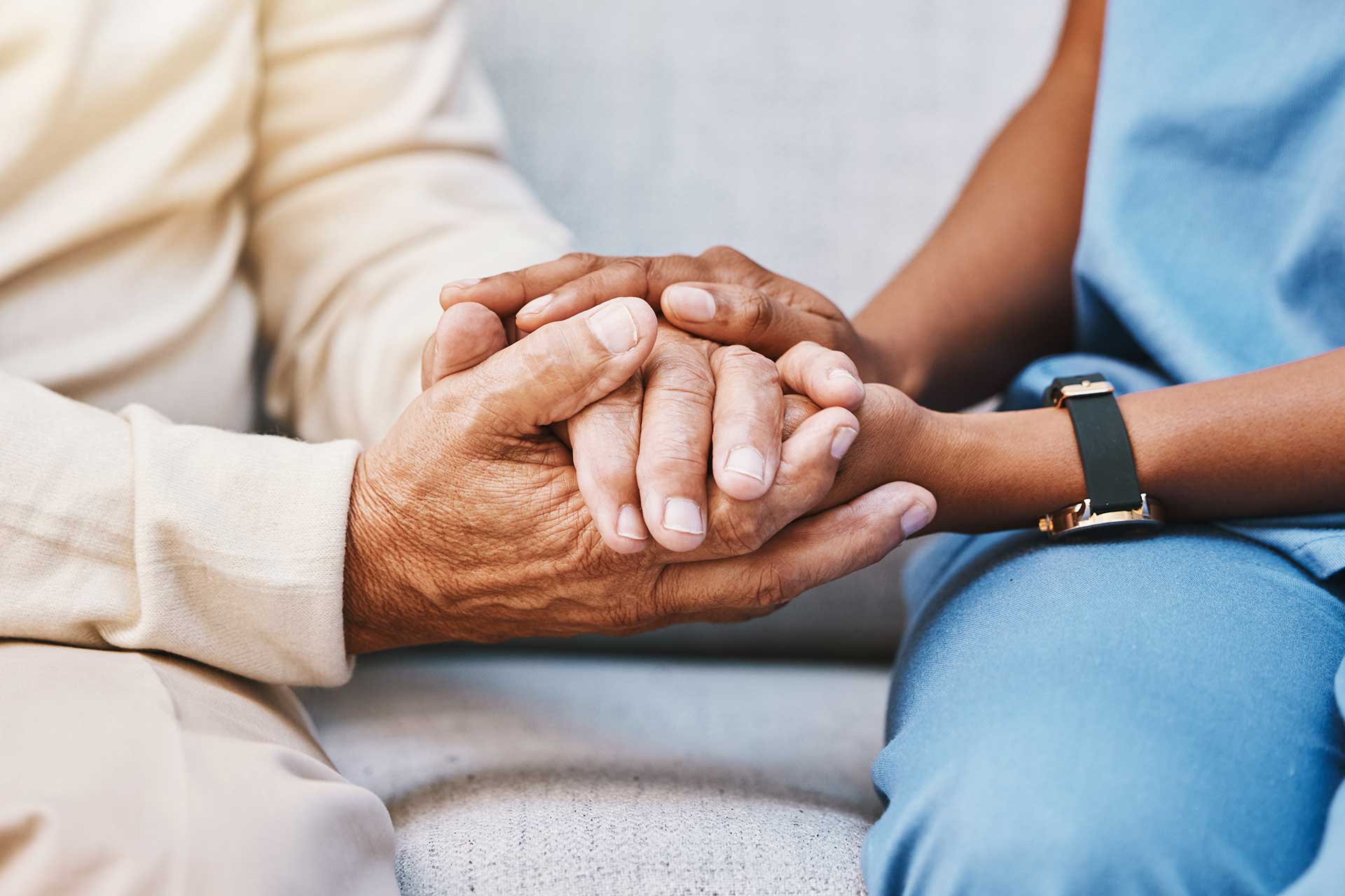 a senior care resident and a community caregiver share a moment while holding hands